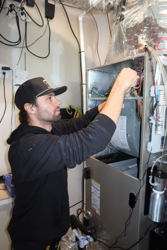 HVAC tech doing repair on a furnace