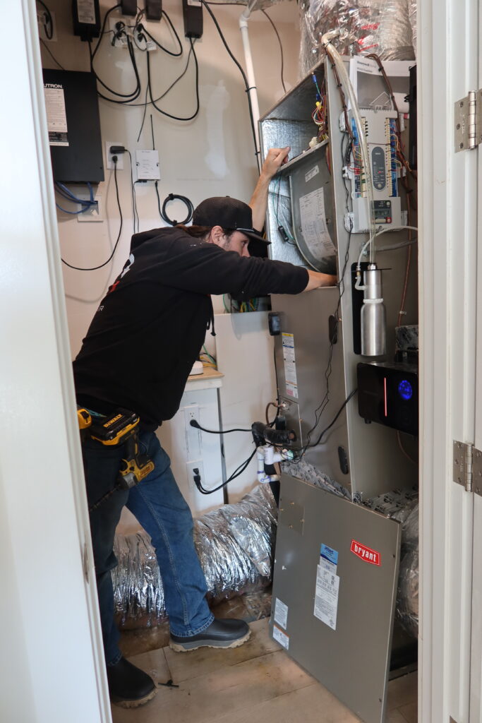 HVAC tech checking a home furnace unit